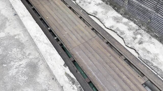 Rusty iron drainage grate on concrete street gutter