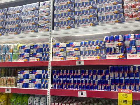 BELO HORIZONTE, MG, BRAZIL, APRIL 11, 2026 A supermarket aisle overwhelmingly stocked with multiple cases and individual cans of Red Bull energy drink on red shelves.