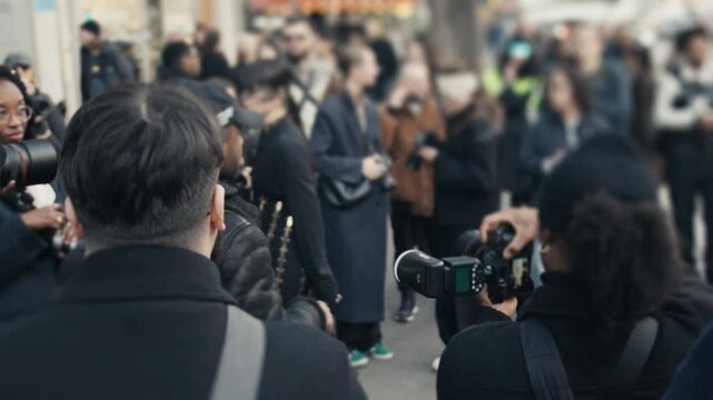 Photographers and paparazzi taking pictures at fashion event
