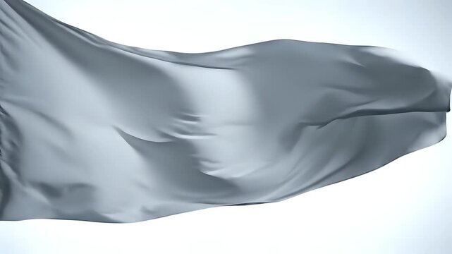 A white flag gently waving in the wind against a bright sky.