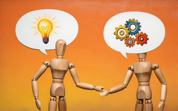 Two wooden figures think differently one with a lightbulb idea the
