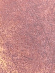 Fototapeta premium Closeup of a weathered rust metal surface showing varied oxidation patterns, brown and orange discoloration, dust accumulation, and uneven corrosion across the deteriorating material.
