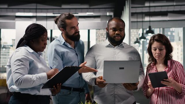 Diverse employees team working on new marketing strategy with reports, sharing ideas and insights for business administration. Colleagues making decisions together in smart office.