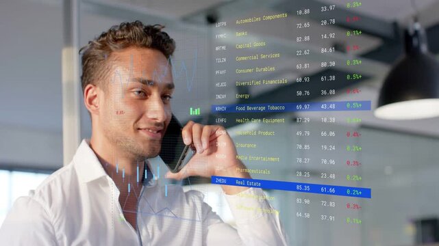 Man holding phone taking call in office while monitoring transparent finance overlay and smiling