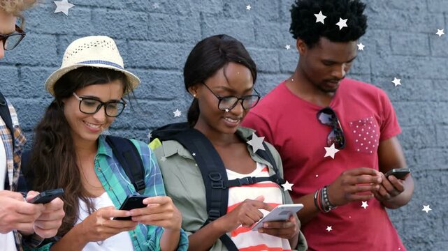 Four students standing by grey brick wall, tapping phones, causing star overlay, checking education