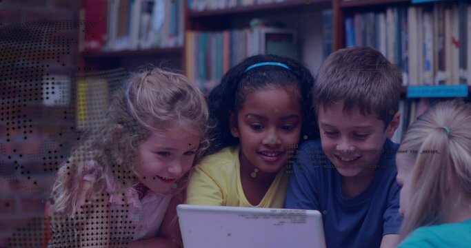 Sharing white laptop, four students leaning around low table in library, wearing bright clothes