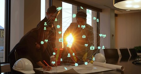 Reviewing 3 staff in suits with hivis vest leaning over plans helmets digital overlay in boardroom © vectorfusionart