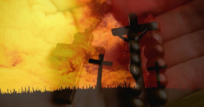 Holding handheld rosary and crucifix resting on palm at grassy horizon, with three shadowed crosses