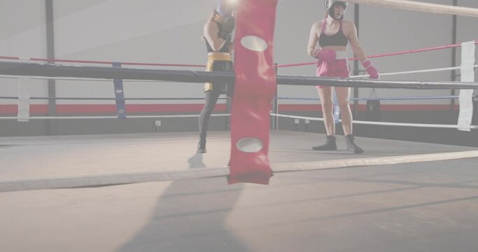 Sparring boxers trading blows in gym ring, red post, ropes, headgear, pink gloves, yellow shorts