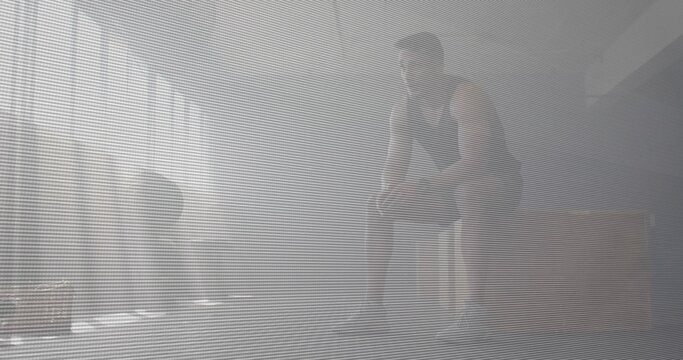 Sitting adult male resting on wooden plyo box in hazy studio, wearing sleeveless top, shoes, blinds