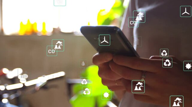 Woman tapping smartphone at kitchen sink, invoking animated sustainability icons and energy graphs