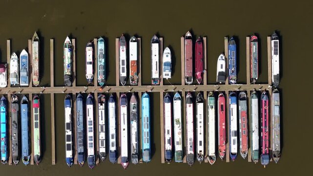 Aerial view of colorful narrowboats moored at the wooden piers of Barton Marina in Barton-under-Needwood, England, United Kingdom.