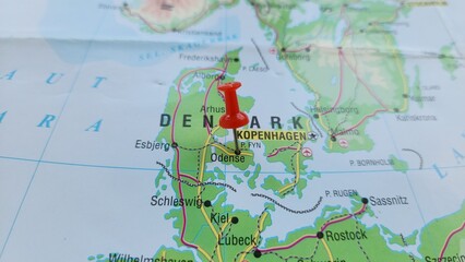 Fototapeta premium View of Odense, is the third largest city in Denmark and the largest city on the island of Funen, on a geographical map of Europe, marked with red push pin