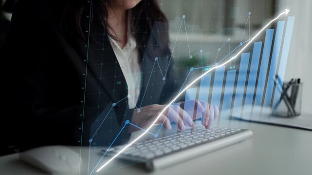 A focused business woman analyzes financial data on her computer, showcasing digital graphs and charts that highlight growth trends and market insights in a sleek office environment. Copula