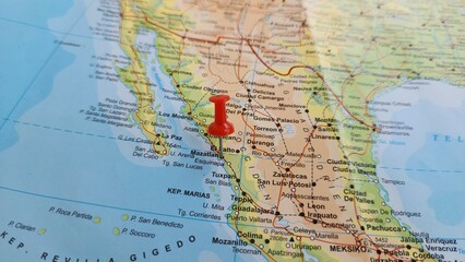Fototapeta premium View of Mazatlan, Municipal seat of Mazatlan, State of Sinaloa, Mexico, on a geographical map of America, marked with red push pin