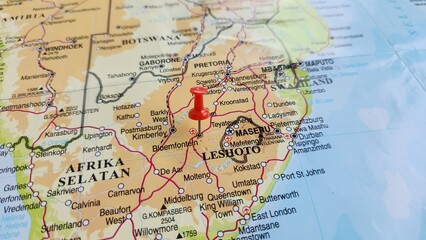 Naklejka premium View of Bloemfontein, also known as Bloem, is the capital and the largest city of the Free State province in South Africa, on a geographical map of Africa, marked with red push pin