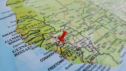 Naklejka premium View of Guinea, officially the Republic of Guinea, is a coastal country in West Africa, on a geographical map of Africa, marked with red push pin