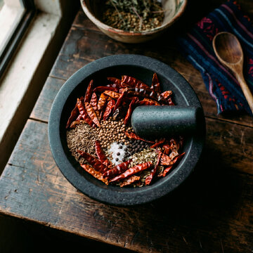 Mortero con chiles secos, pimienta, semillas y sal para cocina tradicional