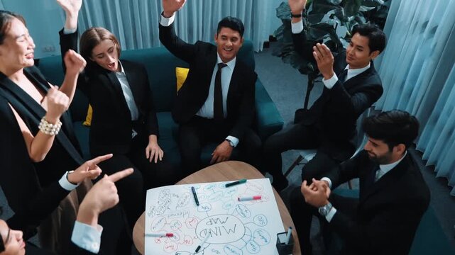 Top view of business people putting hands together and clapping hands to celebrate successful project while using mind map to brainstorm idea. Startup team stacking hands together. Directorate.