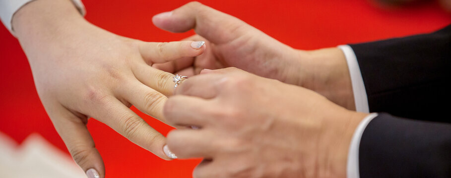 Groom show wedding ring on the box before give to bride in wedding ceremony.  Wedding rings. He Put the Wedding Ring on Her. 