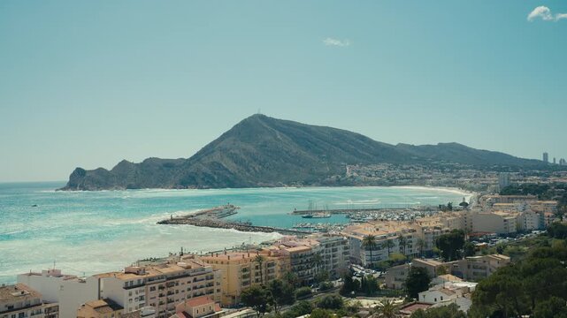 Beautiful view of Altea on the Costa Blanca in Spain, featuring a coastal town, turquoise Mediterranean sea and surrounding mountains under clear sunny skies.