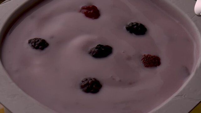 yogurt berries spoon stirring creamy texture closeup food photography healthy breakfast product shot organic fruits motion mix