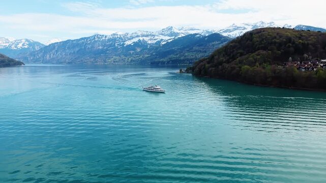 Aerial: big boat sailing on Thun Lake during the day near Spiez, Canton of Bern, Switzerland, orbit drone shot