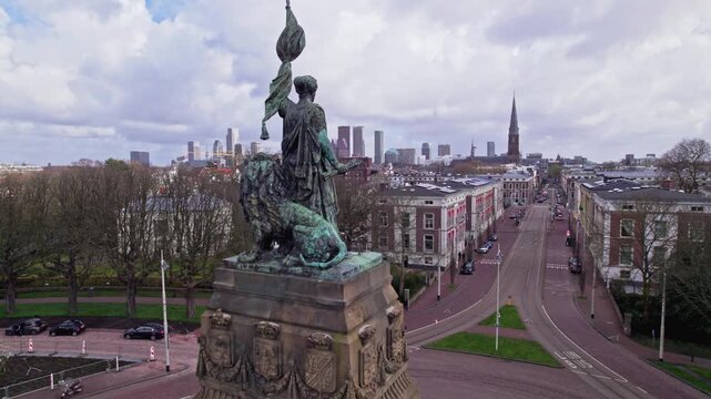 Liberty statue aerial view of Plein 2013 historic monument in Den Haag, The Netherlands with skyline cityscape of The Hague in the background on a sunny and cloudy day