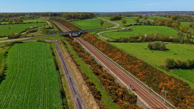 Drone flies over railway and road crossing in Mayenne farmland