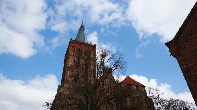 The bell tower of the Church of the Assumption of the Blessed Virgin Mary. Chelmno, Poland. Slow motion x0,5.