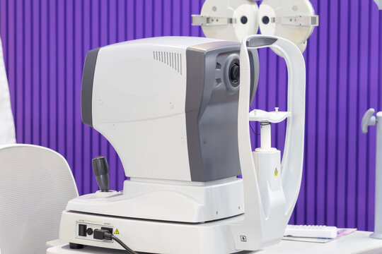 Eye exam equipment in clinical setting with purple wall backdrop
