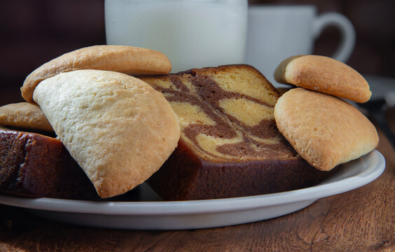 reposteria fina, pan dulce mexicano para desayuno postres o cenas en familia, tradicional. acercamiento o zoom a pan. panque marmoleado con empanadas de cajeta en un plato, con leche y taza de cafe