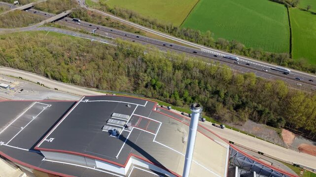 Aerial view of the Encyclis Newhurst ERF industrial facility with its tall chimney next to a busy motorway in Shepshed, England, United Kingdom.