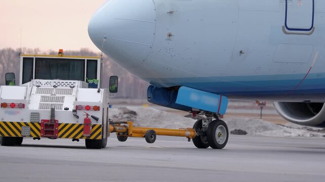 Airplane landing gear runway. Airport terminal maintenance crew aircraft towing vehicle. Close-up of airplane's wheels.