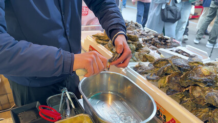 Vendor Shucking Fresh Pacific Oysters at Tsukiji Outer Fish Market in Tokyo © blueringmedia