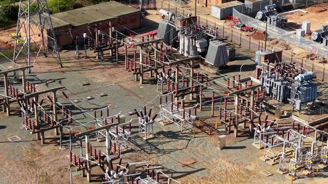 Aerial view of Coalville Substation with transformers and pylons under bright sunlight in Coalville, England, United Kingdom.