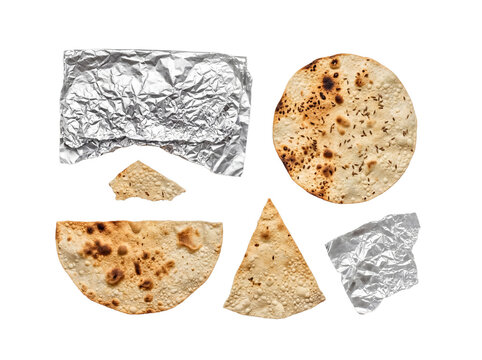 Assorted crispy Indian papadum pieces and crumpled aluminum foil, isolated on a transparent background.