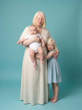 Mother with albinism holding her two childre