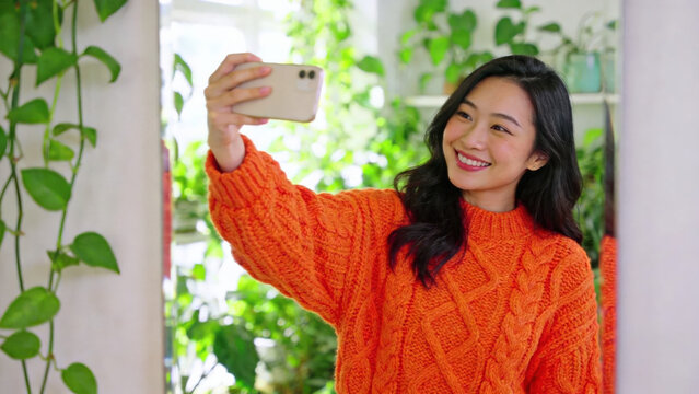 Woman Taking Selfie in Orange Sweater