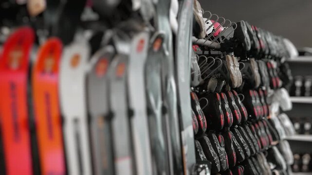 Skis and snowboard boots in rental shop storage and drying system winter resort equipment preparation indoors shallow depth of field.