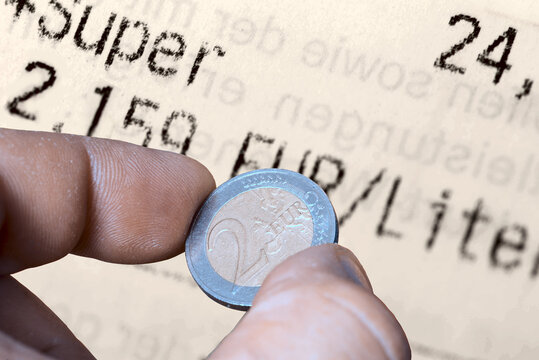 Euro M&uuml;nzen und eine Tankquittung als Symbol f&uuml;r hohe Kraftstoffpreise an den Tankstellen