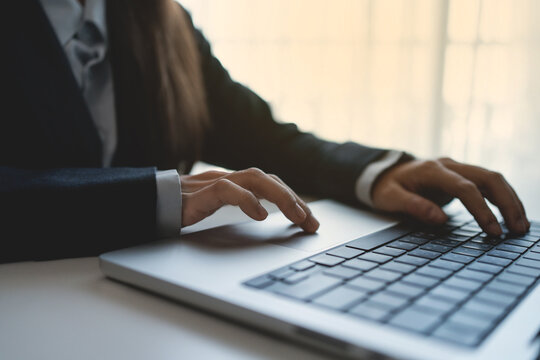 The hands of a professional businessperson are intently typing on a laptop keyboard. Work and communication are essential.