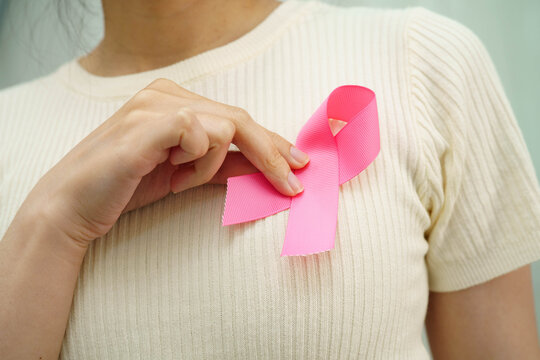 Asian woman with pink ribbon for October world breast cancer day.