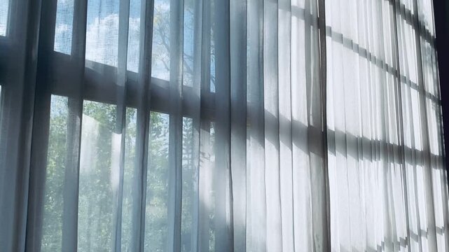 Abstract leaf shadows on soft fabric curtain with natural sunlight.