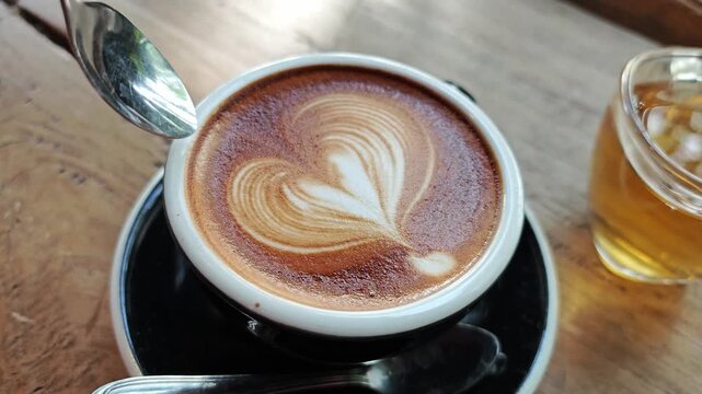 Close up of latte art creation, milk poured from a mug.