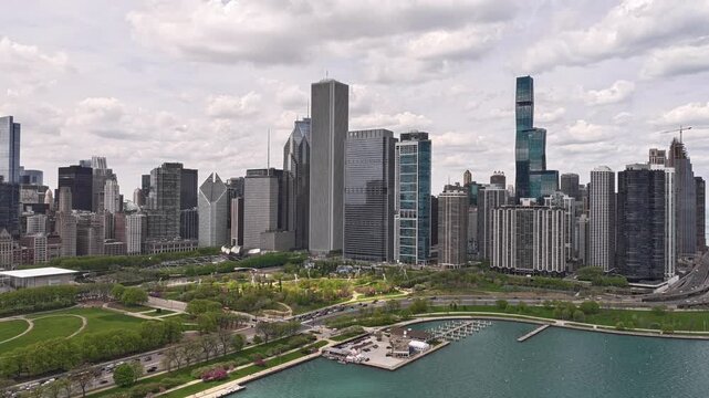 Aerial time lapse of Chicago Lakefront Trail along Lake Michigan with downtown skyline, beautiful spring afternoon, moving clouds, urban waterfront activity, Chicago Illinois USA, cinemat