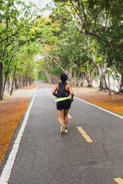 Unidentified woman exercise jogging in a park.