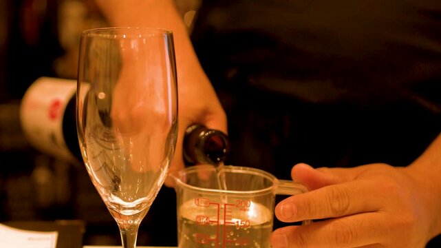 Japanese Sommelier Pouring Sake into a Measuring Cup in Kanazawa