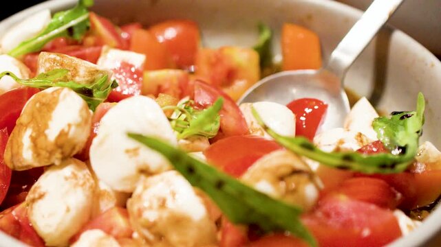 Serving Fresh Caprese Salad with Mozzarella Balls and Cherry Tomatoes