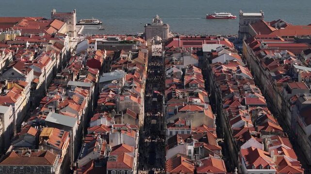 Aerial view of the historic Rua Augusta leading to Praca do Comercio with red rooftops and boats on the Tagus River in Lisbon, Lisbon, Portugal.